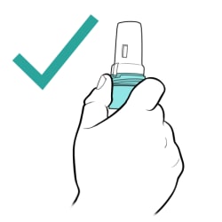 Green check mark and hand holding bottom of inhaler upright.