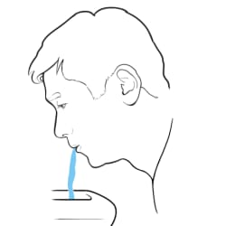 Person spitting water into sink.