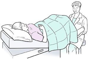 Health care provider giving woman pelvic exam.