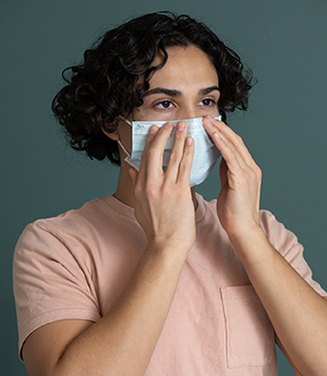 Person putting on medical face mask.