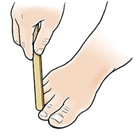 Hand with nail file filing down callus on toe.