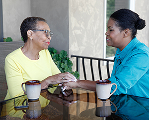 Two women sitting outdoors talking.