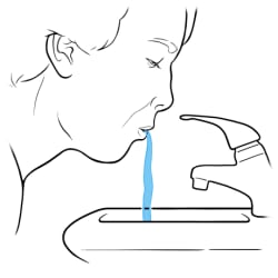 Person spitting water into sink.