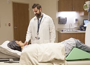 Technician preparing woman for X-ray.