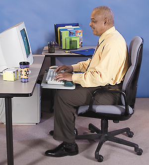 Man sitting in office chair using computer