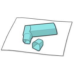 Cap lying next to inhaler on paper towel.