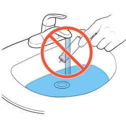 A "no" symbol over canister being held under faucet with running water.