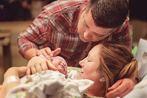 Couple in hospital holding their newborn baby.