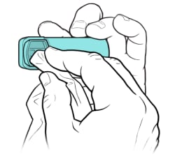 One hand holding inhaler, with other hand using cloth to clean mouthpiece.