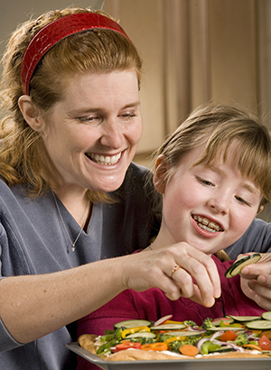 Woman and girl preparing food.