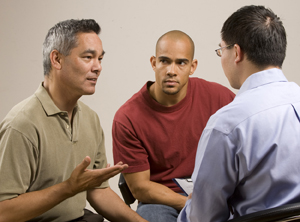 Two men in group discussion with health care provider.
