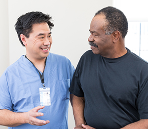 Healthcare provider talking to man in exam room.