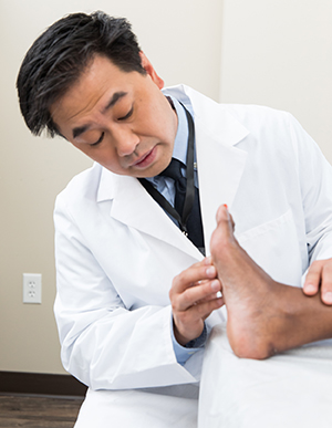 Healthcare provider examining woman's foot.
