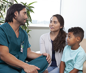 Healthcare provider talking to woman and boy.