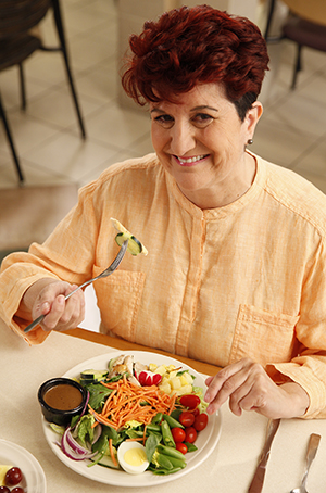 Mujer comiendo ensalada.