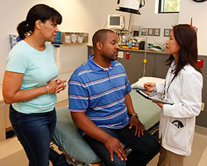 People talking to doctor in exam room.