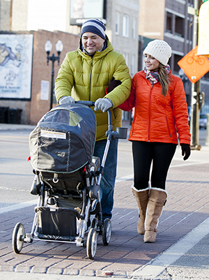 Man and woman walking baby in stroller.