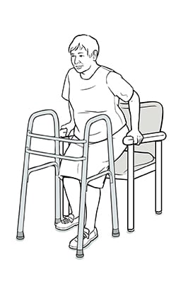 Person with hands on arms of chair and lowering self into chair, keeping operated leg slightly out in front.