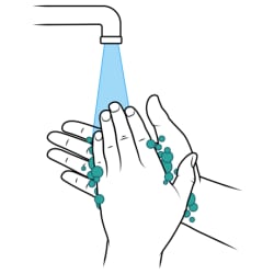 Manos frotadas con jabón bajo el grifo con agua corriente.